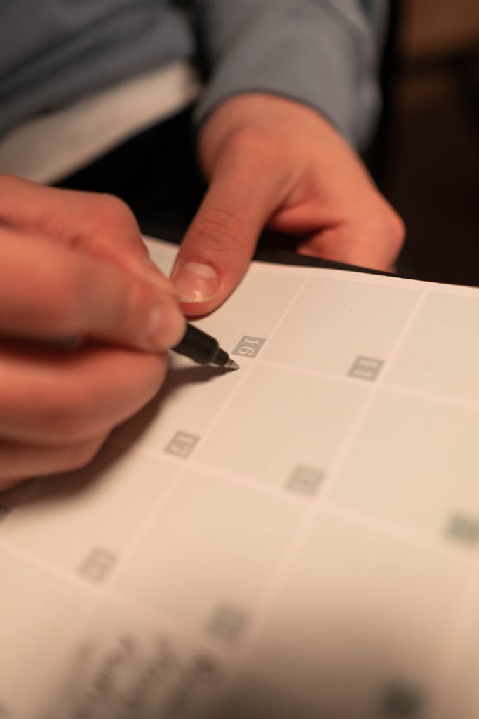 Close-up of a hand writing on a calendar representing Lifespan Health FAQ on appointments