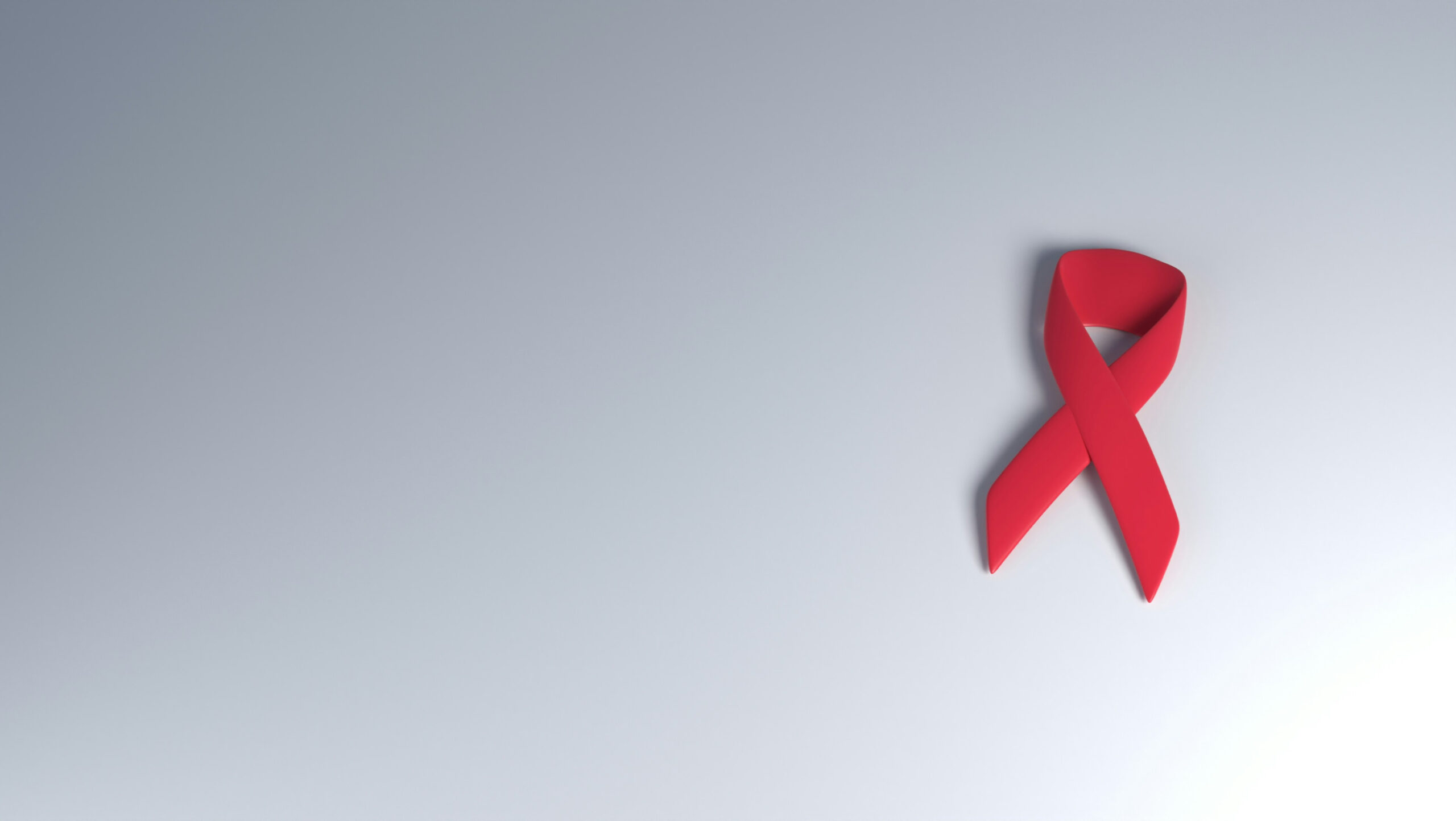 Red ribbon on a dark background as a symbol for integrative cancer support